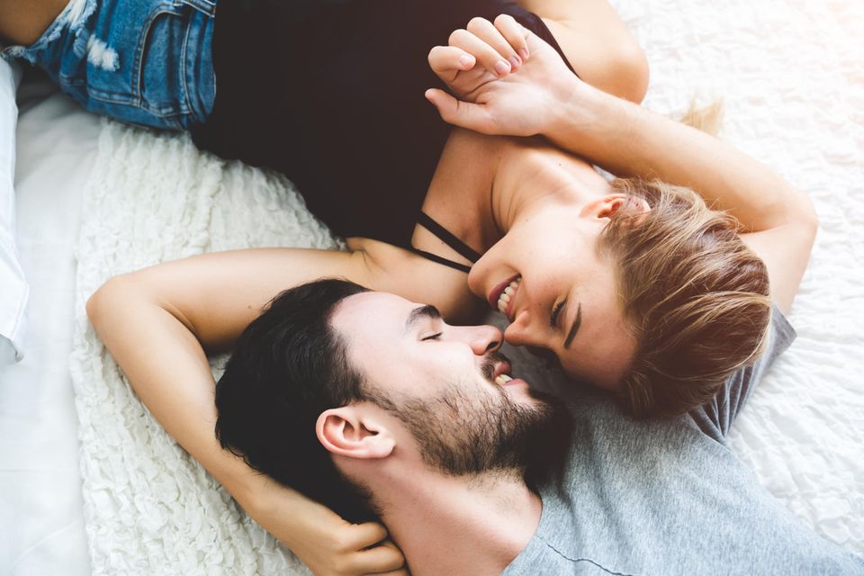 Kosenamen: Frau und Mann kuscheln verliebt auf dem Bett