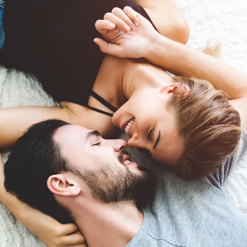 Kosenamen: Frau und Mann kuscheln verliebt auf dem Bett. 