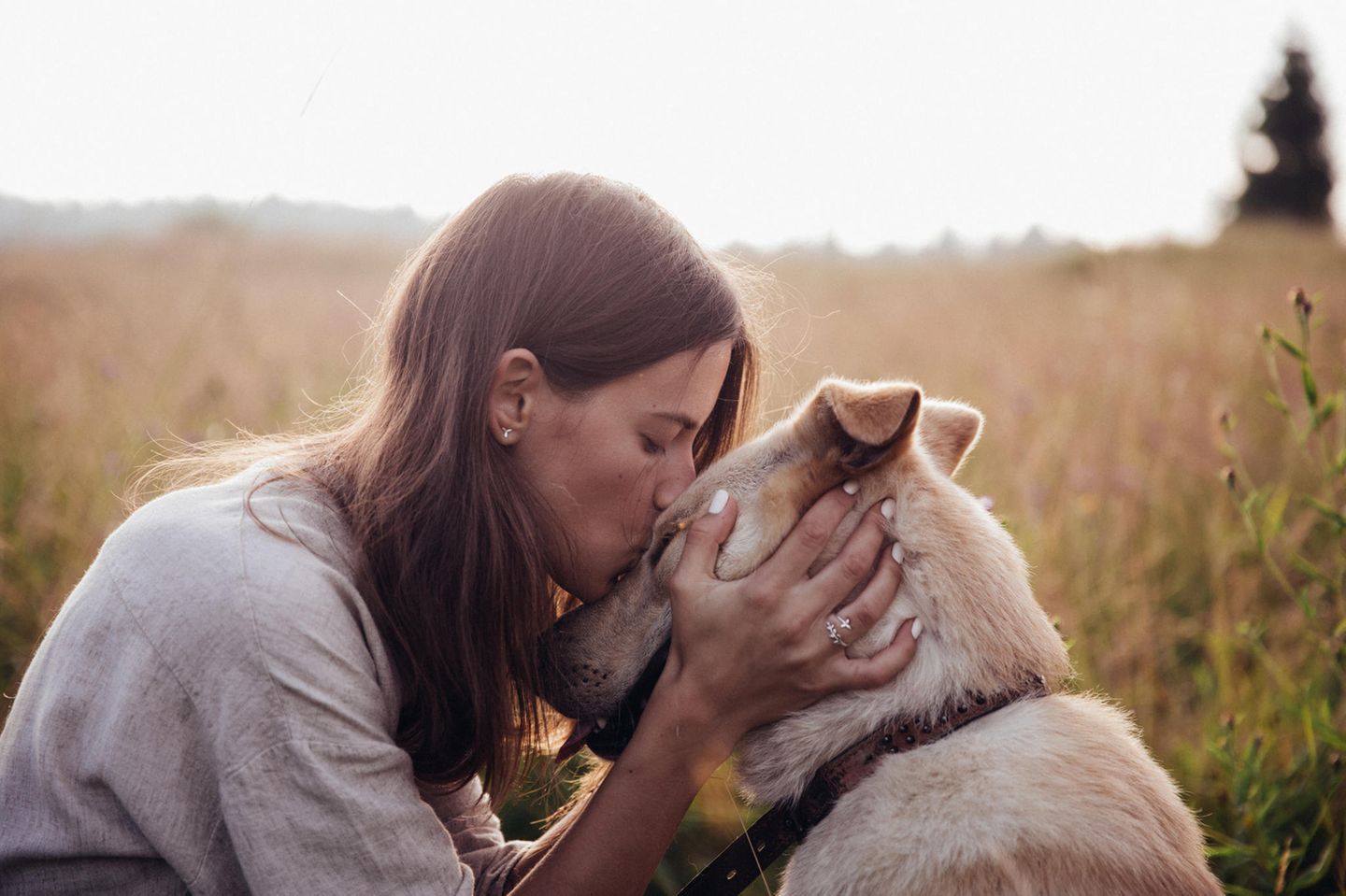 Hunde-Horoskop: Frau küsst den Kopf ihres Hundes