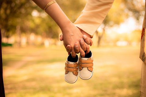 Schwangerschaft verheimlichen: Paar hält Baby-Schuhe