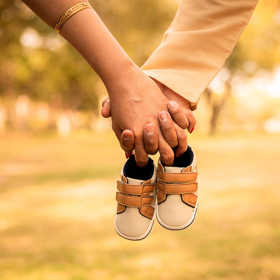 Schwangerschaft verheimlichen: Paar hält Baby-Schuhe
