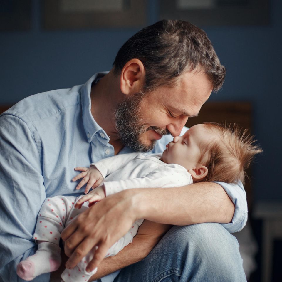 Bezahlte Freistellung für Partner: Vater hält Baby