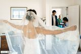 Hochzeitsfotografie: Braut erwartet Bräutigam im Zimmer