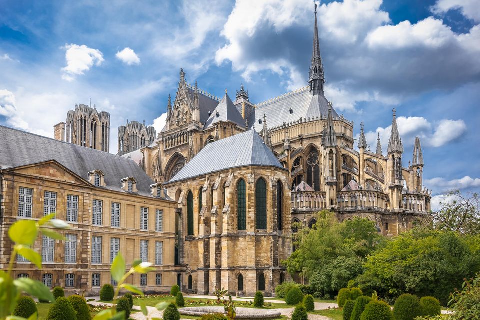 Champagne: die Rückansicht einer großen französischen Kathedrale aus beigen Stein, grauem Dach und vielen spitzen Türmchen