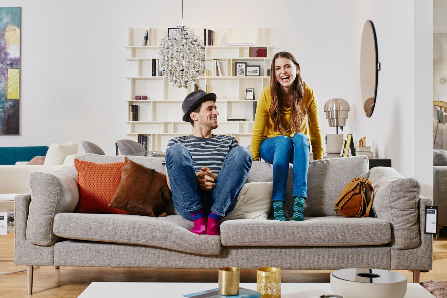 Ein Mann und eine Frau sitzen auf einer Couch und lächeln.