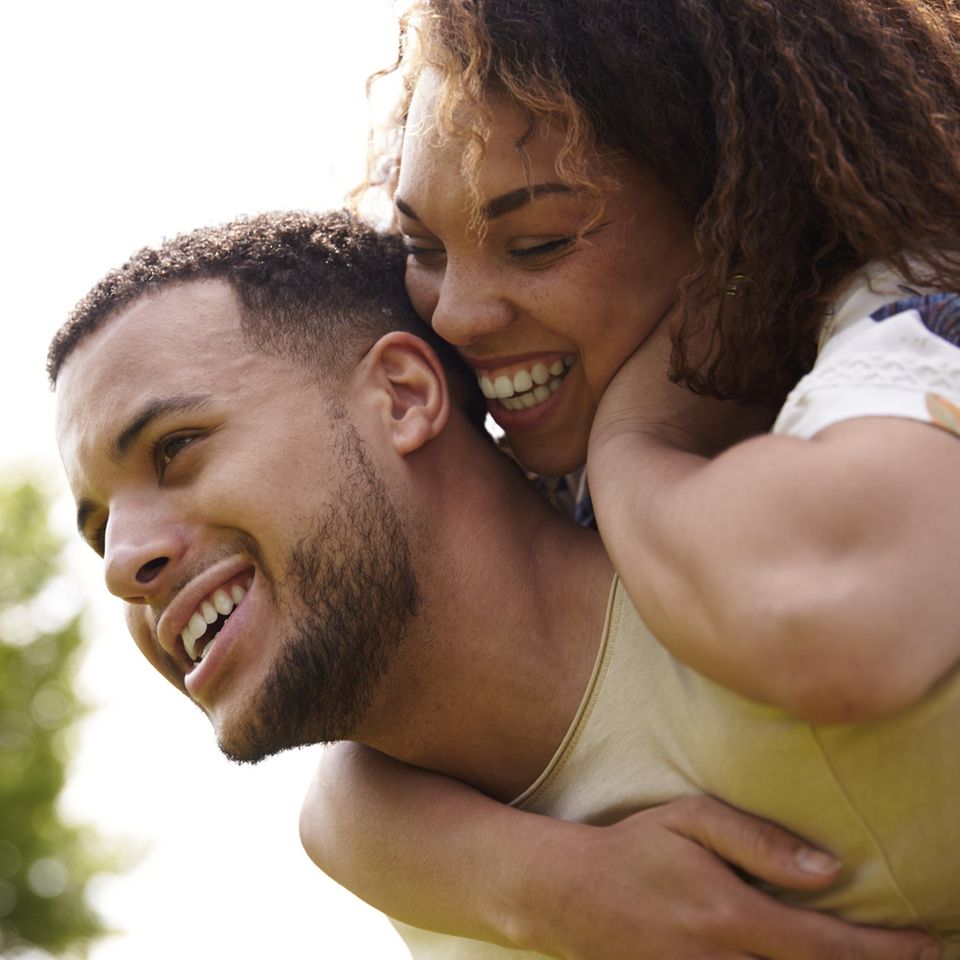 Lachendes Paar in der Natur: Der wesentliche Unterschied zwischen glücklichen und unglücklichen Paaren