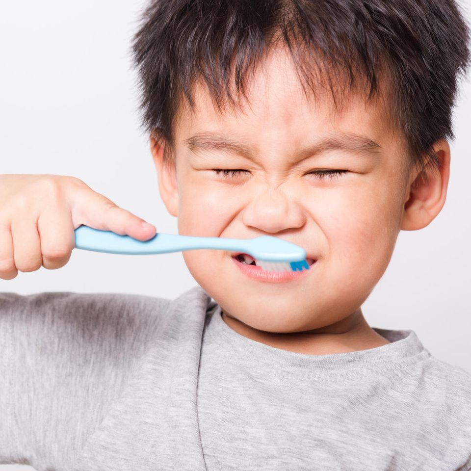 Eine Junge putzt sich die Zähne.