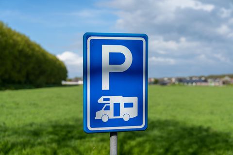Wohnmobile im Wohngebiet: ein blaues Parkplatz-Schild mit einem Wohnmobil