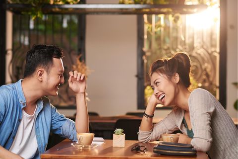 Eine Frau und ein Mann lachen beim ersten Date.