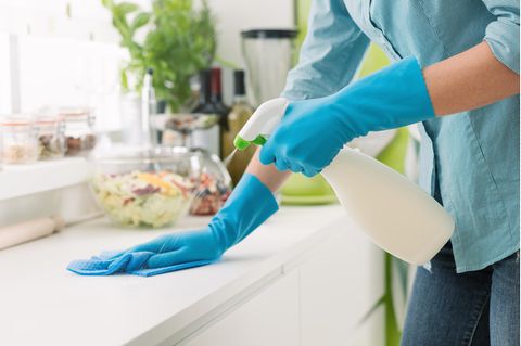 Eine Frau putzt die Arbeitsfläche.