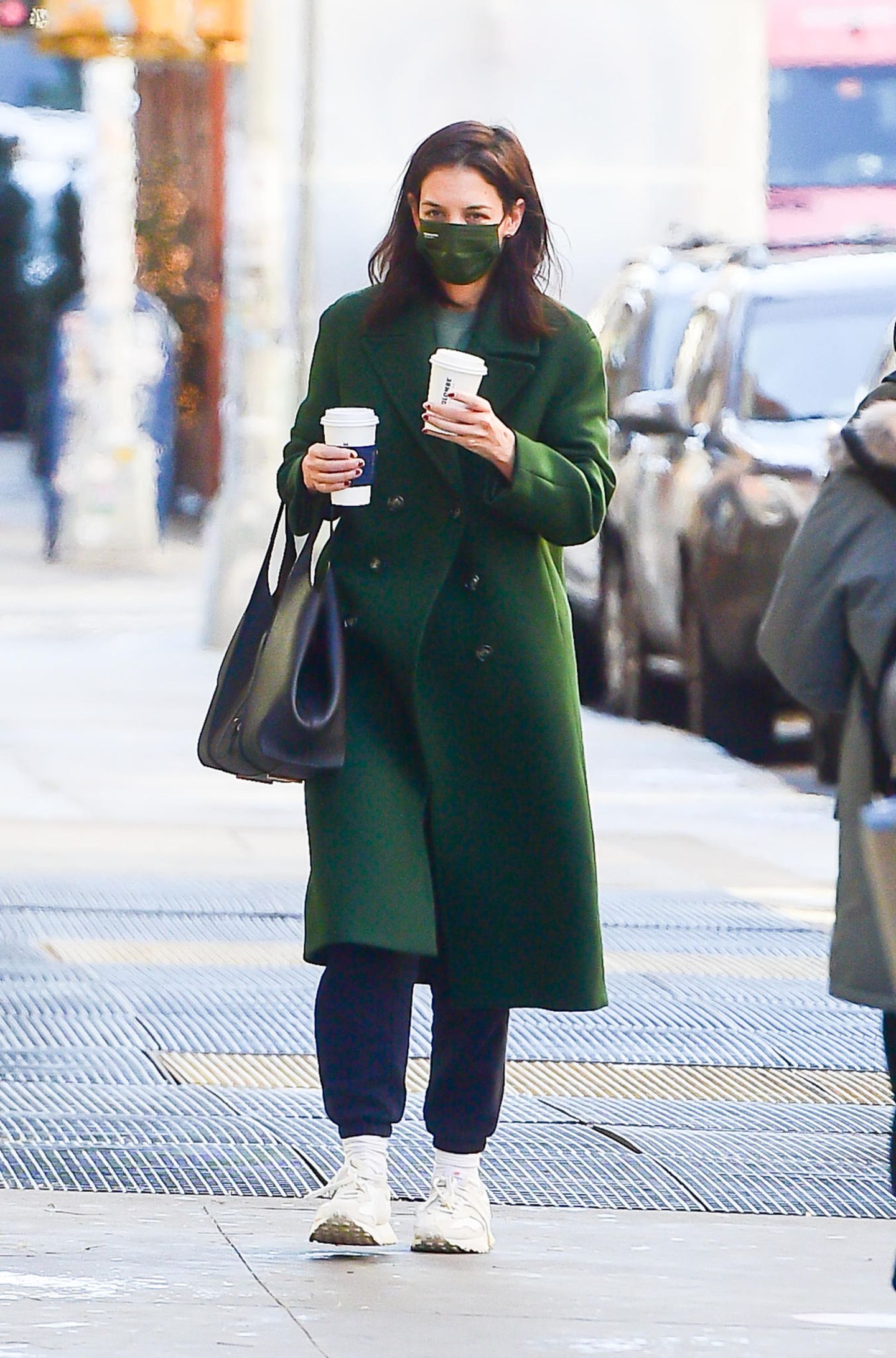 Katie Holmes überlasst nichts dem Zufall: Auf den Straßen New Yorks zeigt sie sich sogar mit farblich abgestimmter Maske. Den dunkelgrünen Mantel hat die Schauspielerin übrigens von Mango. Dazu eine dunkelblaue Jogginghose, weiße Sneaker und ein Shopper – fertig ist der Coffe-Walk-Look. Eine Frage bleibt allerdings offen: Für wen wohl der zweite Becher Kaffee ist?