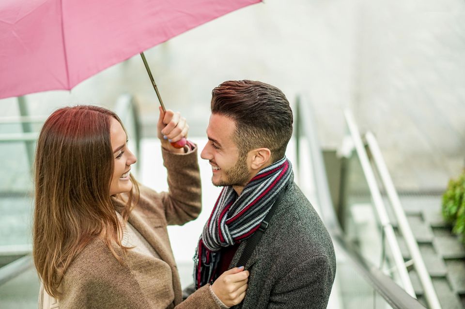 Glückliches Pärchen mit pinkem Regenschirm
