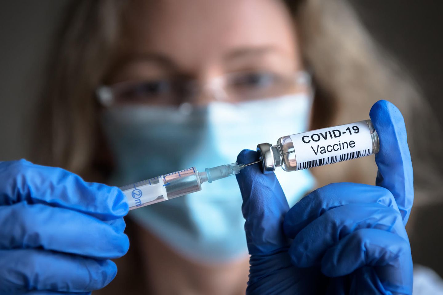Corona akuell: Frau zieh Covid-Impfung mit einer Spritze auf