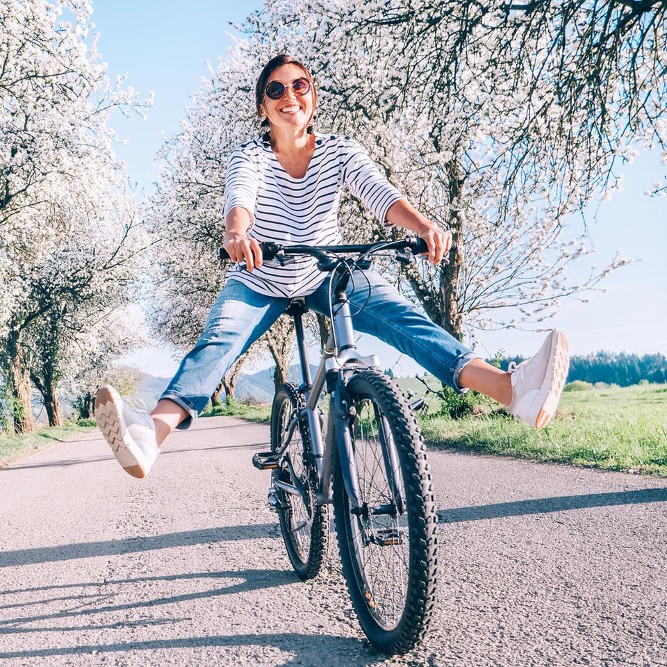 Frau fährt Fahrrad: An diesen Anzeichen erkennst du einen gesunden Stoffwechsel