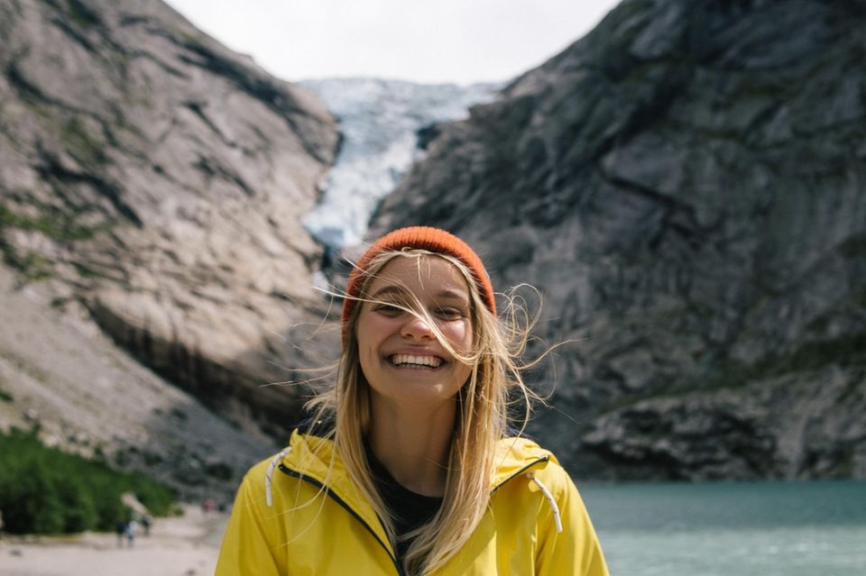 Psychologie: Eine fröhliche Frau an einem Gletscher