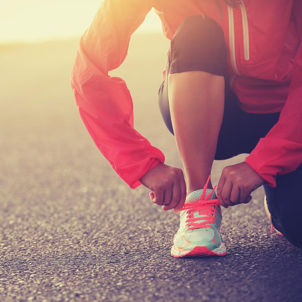 Motivation zum Abnehmen: Läufer schnürt sich die Sportschuhe