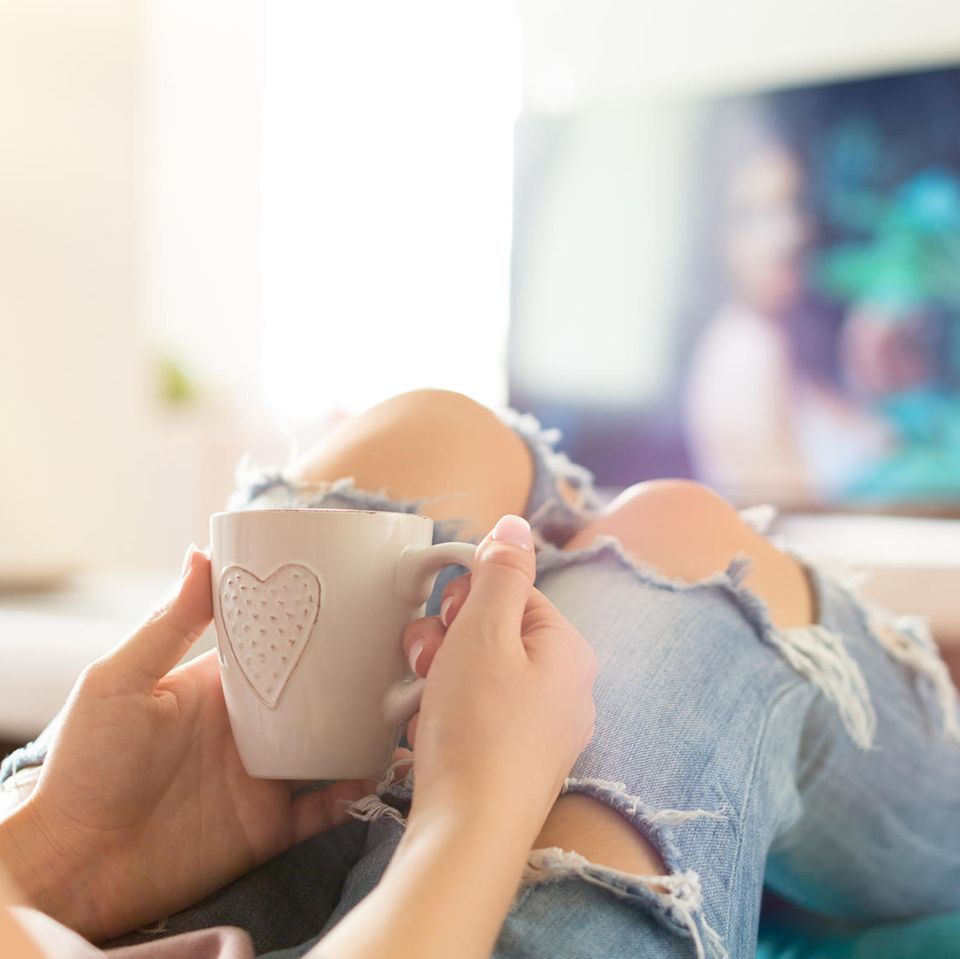 Frau schaut Fernsehen: Binge-Watching ist gar so nicht ungesund – wenn du eine Sache beachtest