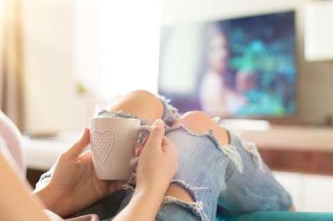 Frau schaut Fernsehen: Binge-Watching ist gar so nicht ungesund – wenn du eine Sache beachtest