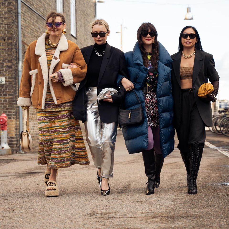 Vier Frauen laufen auf der Copenhagen Fashion Week durch eine Straße