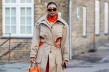 Cut-Outs werden in Kopenhagen nicht nur in Kleidern getragen, sondern auch im Trenchcoat. Die orangefarbenen Highlights geben dem Look frische Akzente. 