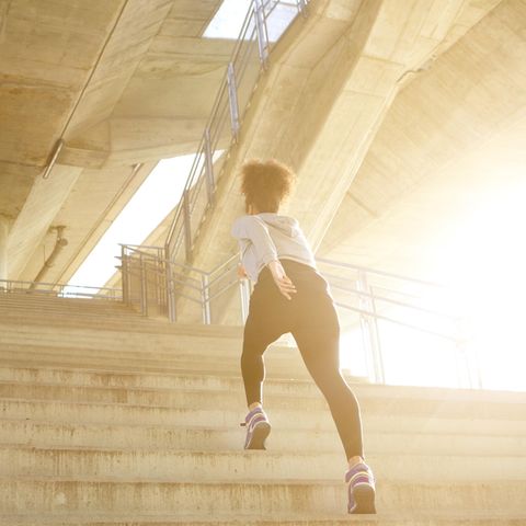 Frau steigt Treppen: Diese 5 Fitness-Hacks machen deinen Spaziergang zum Workout