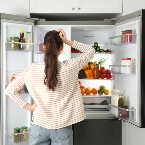 Frau vor geöffnetem Kühlschrank
