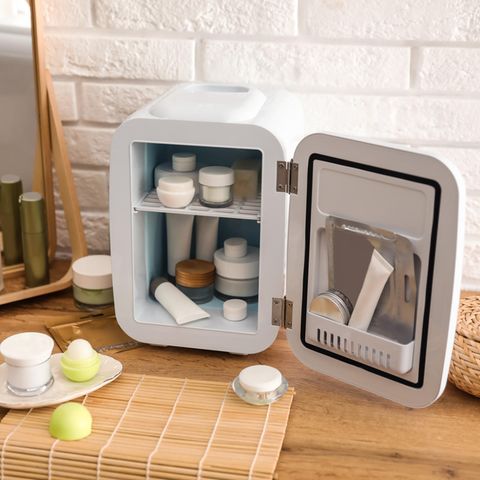 Beauty-Kühlschrank: Kleiner Kühlschrank gefüllt mit Pflegeprodukten und Gesichtsmasken