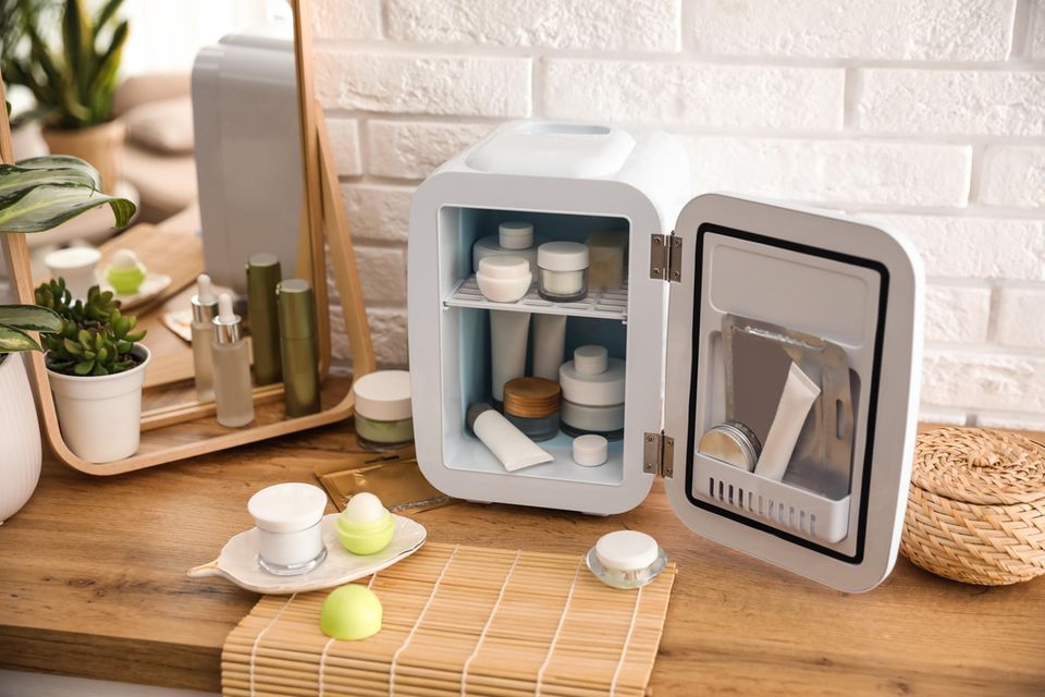Beauty-Kühlschrank: Kleiner Kühlschrank gefüllt mit Pflegeprodukten und Gesichtsmasken