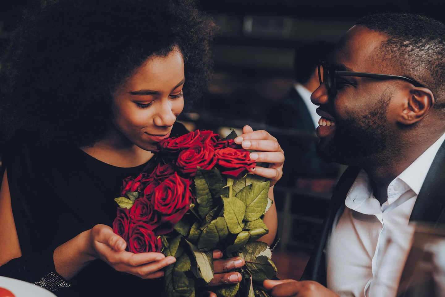 Liebesbeweise: Mann schenkt seiner Frau rote Rosen