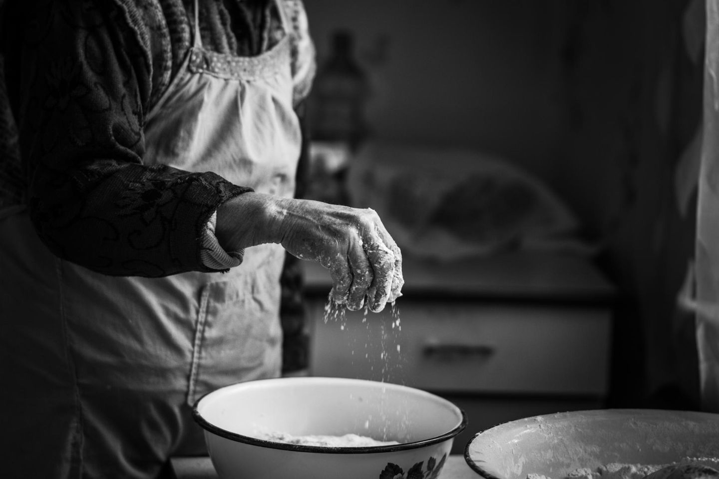 Omas Küchentipps: Eine Hand streut Mehl in den Teig