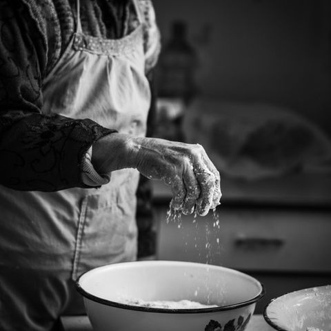 Omas Küchentipps: Eine Hand streut Mehl in den Teig