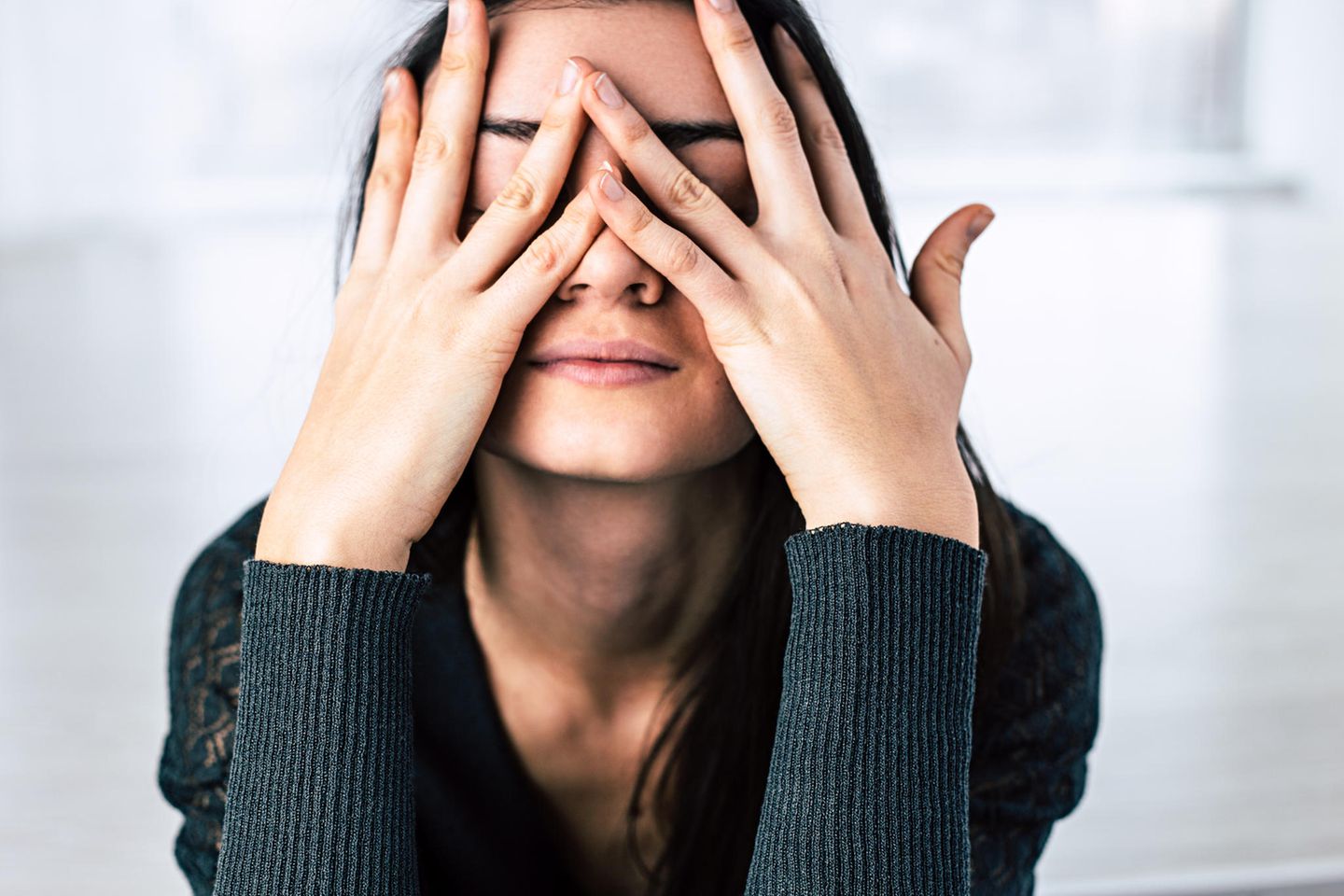 Tipps gegen Stress: Frau mit Händen vor dem Gesicht