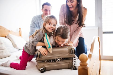 Eine kleine Familie packt einen Koffer.
