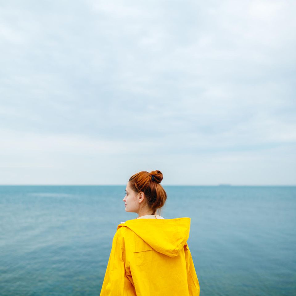Frau schaut nachdenklich aufs Meer: Darum fällt es uns wirklich so schwer loszulassen
