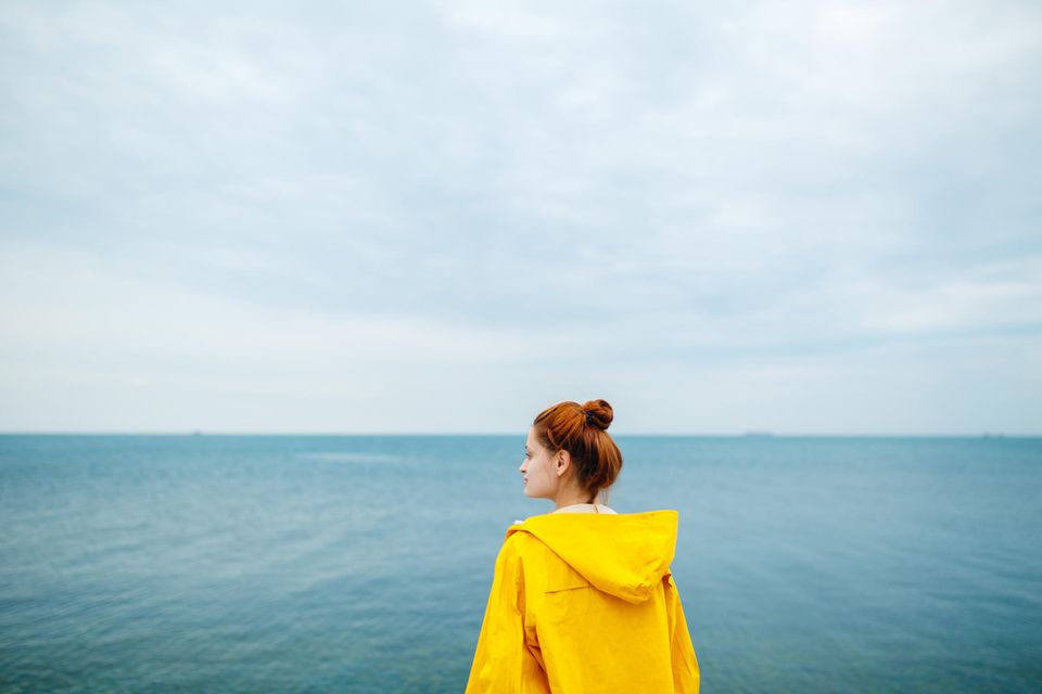 Frau schaut nachdenklich aufs Meer: Darum fällt es uns wirklich so schwer loszulassen
