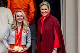 Königin Máxima und König Willem-Alexander sind stolz auf die niederländischen Olympionik:innen, die im Wettkampf 17 Medaillen holen konnten. Für die Ehrung trägt Máxima zum hellroten Wollkleid von Natan Couture einen Cape-Mantel von Valentino in Dunkelrot und dazu Gianvito-Rossi-Pumps. 