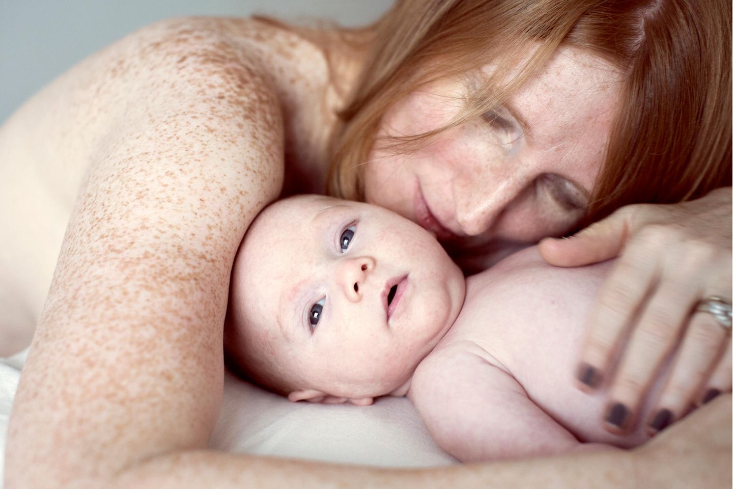 Babyentwicklung: Mutter kuschelt mit ihrem Säugling