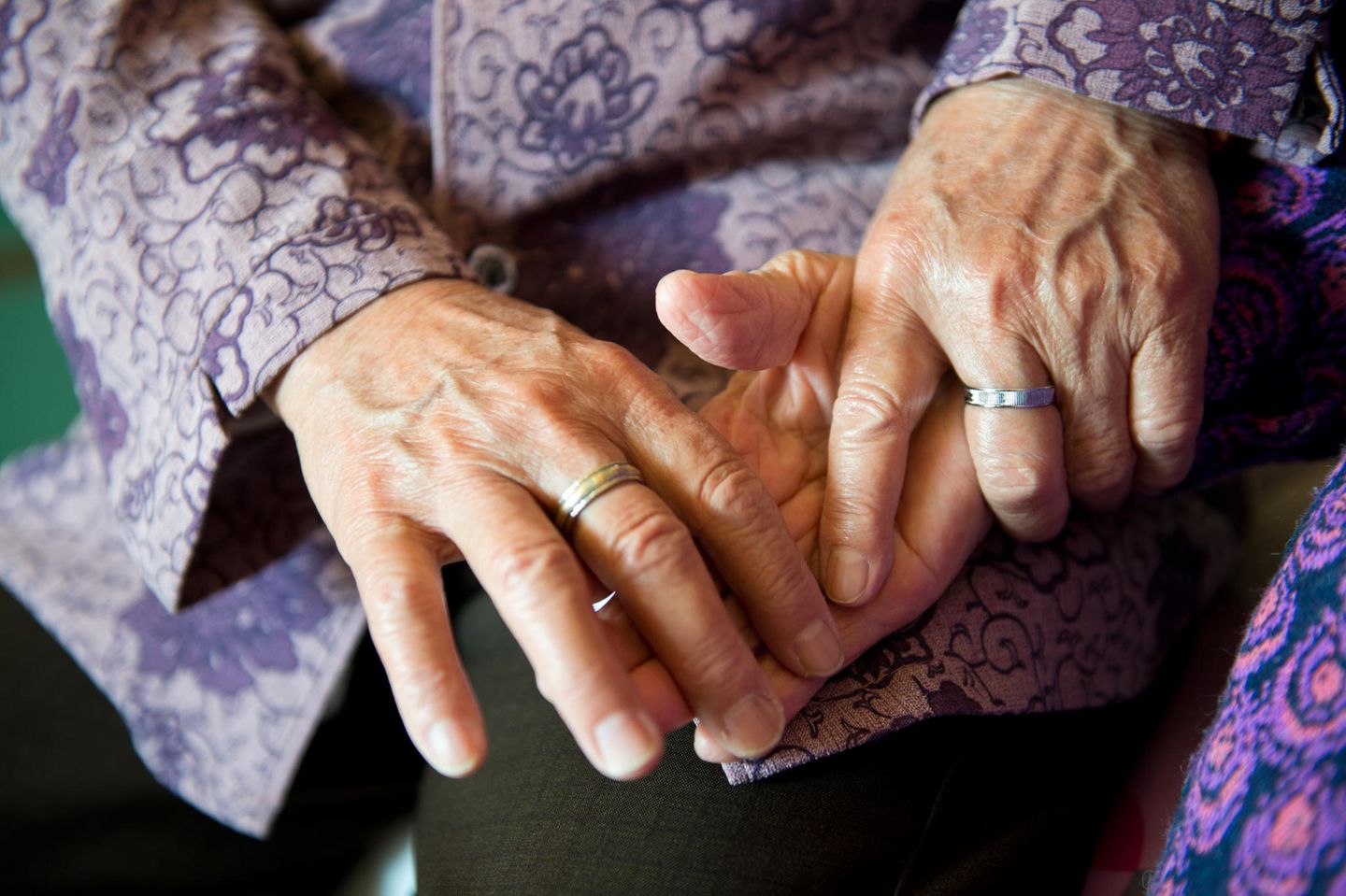 Hundertjährige Zwillinge: Zwei alte Damen halten Händchen