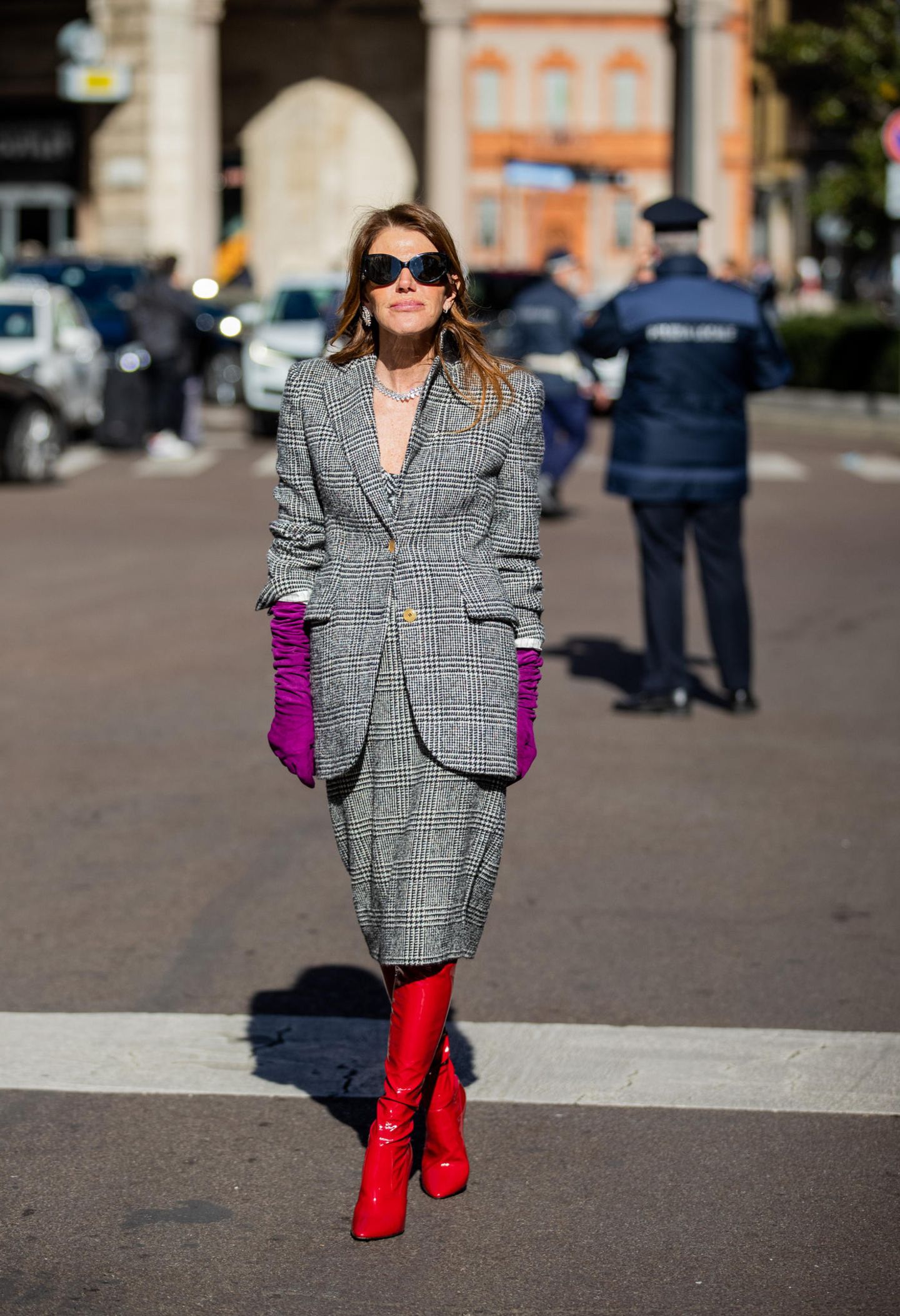 Während das Kostüm von Anna dello Russo einen klassischen Flair versprüht, dürfen ihre Accessoires so richtig knallen. Die roten Lackstiefel in Kombination mit den violetten Handschuhen sorgen dafür, dass der Look der italienischen Modejournalistin definitiv im Gedächtnis bleibt.