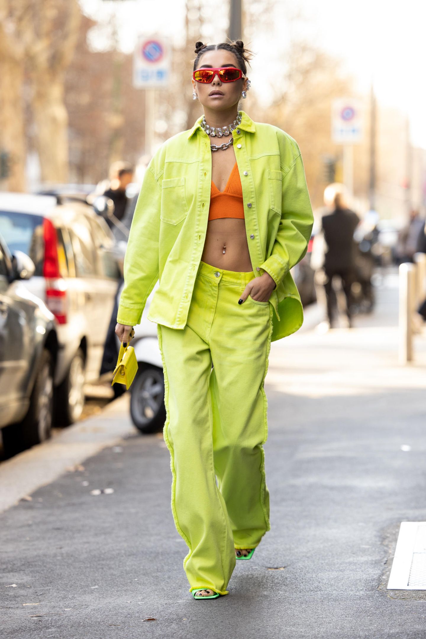 Karina Nigay setzt auf frische Farben. Ihr Outfit in Limettengrün, Orange und Gelb erinnert dabei an einen sommerlichen Cocktail und entführt uns von Mailand direkt an die Copacabana – cheers!