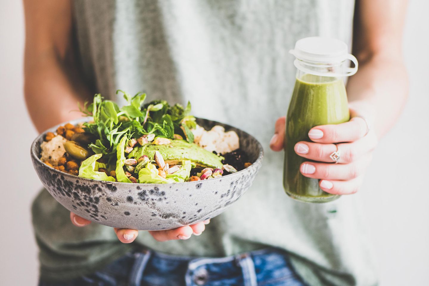 Unbemerkte Essstörung: eine Frau hält eine Bowl mit Gemüse und einen grünen Smoothie in den Händen