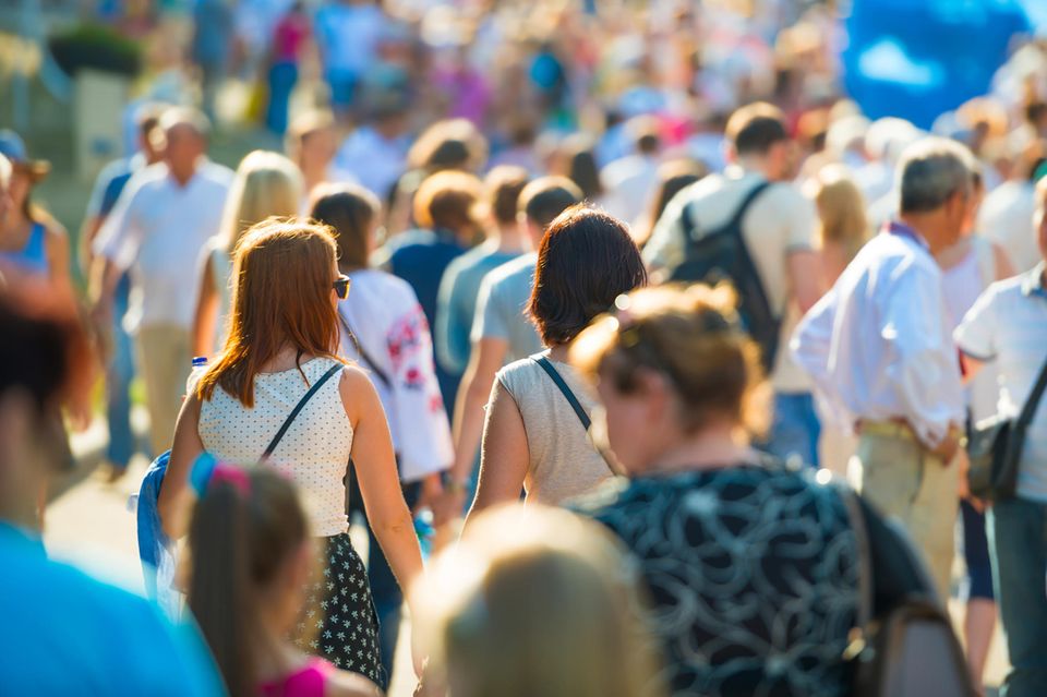 Menschen gehen in der Sonne spazieren