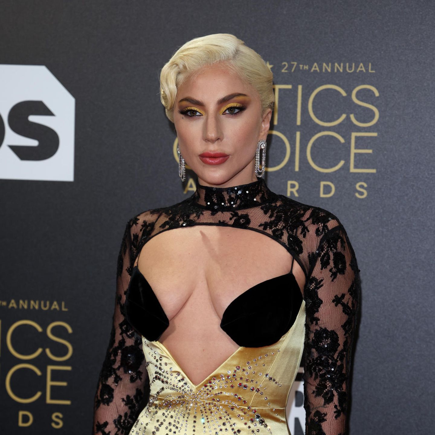 Mit Cat-Eyes in Gelbtönen und großen Statement-Ohrringen zeigt Lady Gaga einmal mehr wie viel Glamour in ihr steckt. Ihr aufregendes Make-Up wird durch ihr Outfit in den selben Tönen und mit glitzernden Pailletten und Strasssteinen perfekt aufgegriffen.