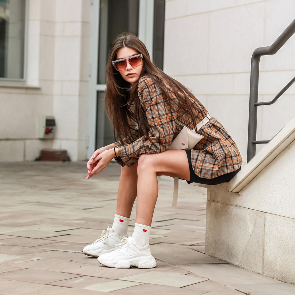 brünette junge Frau mit weißen Sneaker mit Plateau-Sohle