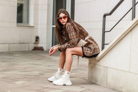 brünette junge Frau mit weißen Sneaker mit Plateau-Sohle