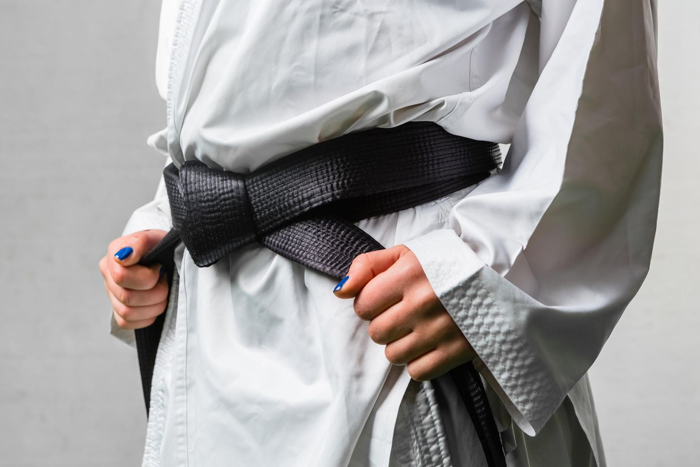 Marina Salewski: eine Frau mit blauem Nagellack binden einen schwarzen Karate Gurt
