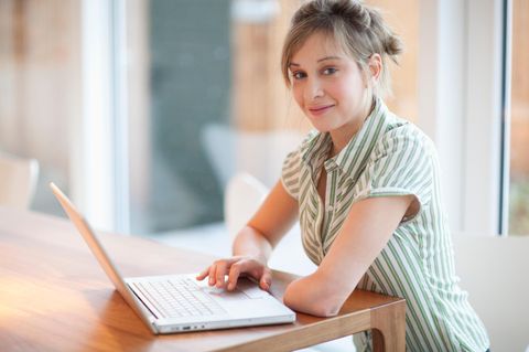 Karriere bei Behinderung: eine junge Frau mit amputiertem Arm sitzt an einem Laptop