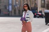Leo Eberlin kombiniert während der Fashion Week in Berlin eine orangefarbene Sonnenbrille, ein pinkfarbenes Oberteil, einen kurzen Rock aus orangefarbenem Tweed und eine marinefarbene Jacke von Prada. Als Accessoire hat sich die Schmuckdesignerin für eine lilafarbene Chanel Mini Bag entschieden.