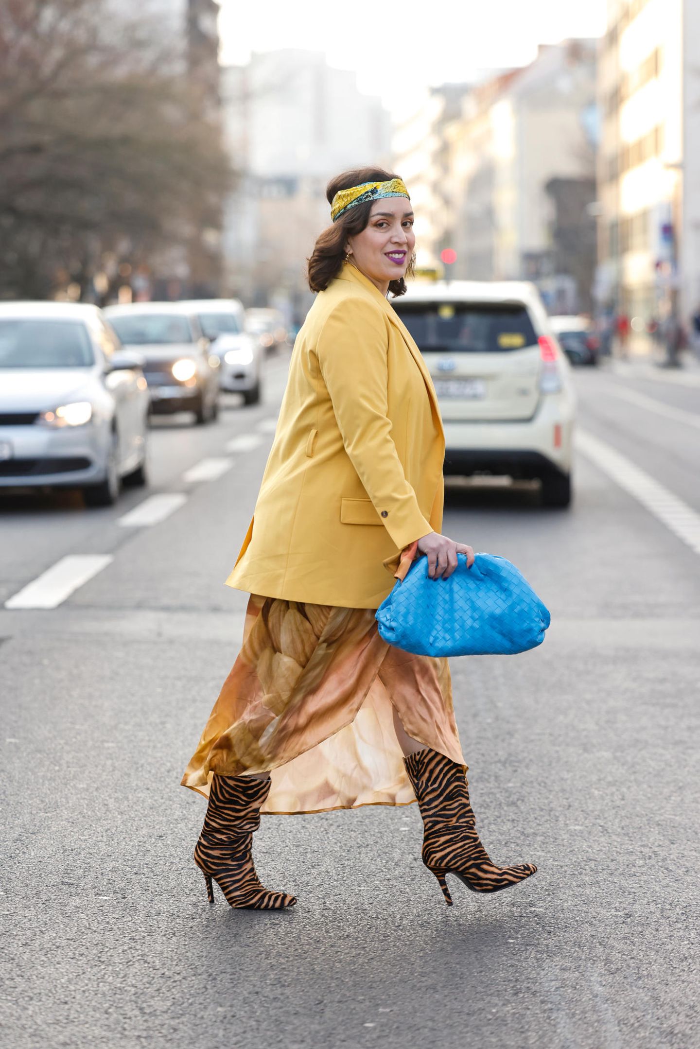 Solidarische Zeichen fanden sich auch in einigen Streetstyle-Looks der Berlin Fashion Week wieder. Influencerin Claudia Vogel kombiniert eine blaue Clutch zu einem gelben Blazer und vereint so die ukrainischen Farben in ihrem Outfit. Ihr Wickelkleid und ihre Schuhe mit Animal-Print hält sie in Gelbtönen.