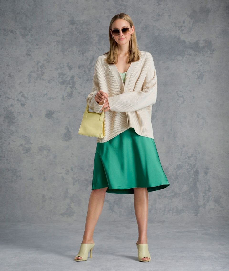 Guido, geht das so? Der beste Look zum Draußen sitzen Guido, geht das so: Charlotte im Satinrock mit Strickjacke und hohen Schuhen